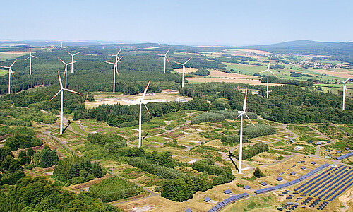 Das Bild zeigt Windkraft- und Solaranlagen auf einem ehemaligen Truppenübungsplatz.
