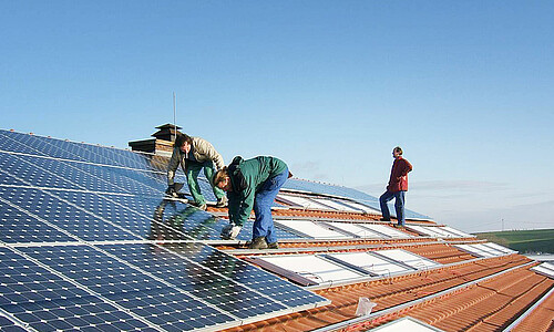 Das Bild zeigt das Verlegen einer Solaranlage auf einem Dach.